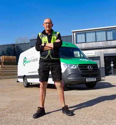 Alpha wholesale employee standing in front of delivery van
